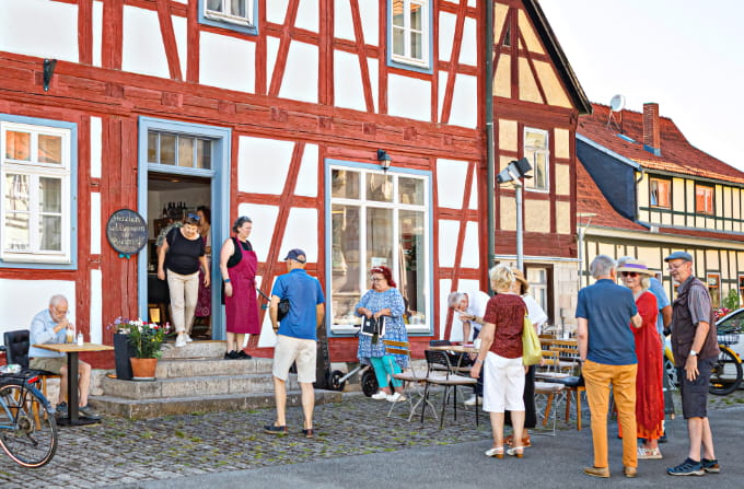 Gäste vor dem Bürgercafé Ummerstadt an einem historischen Fachwerkhaus.